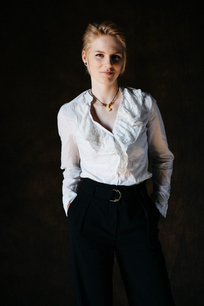 Karina May - Portrait stehend weiße Bluse - über mich